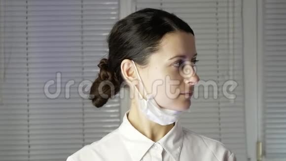 带手套的年轻女医生戴上医用口罩视频的预览图