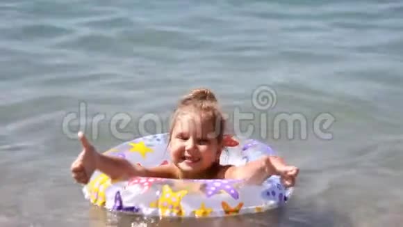 儿童用救生圈在海里洗澡有救生圈的女孩在水里游泳视频的预览图