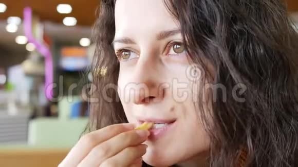年轻漂亮的黑发女孩在快餐店微笑视频的预览图