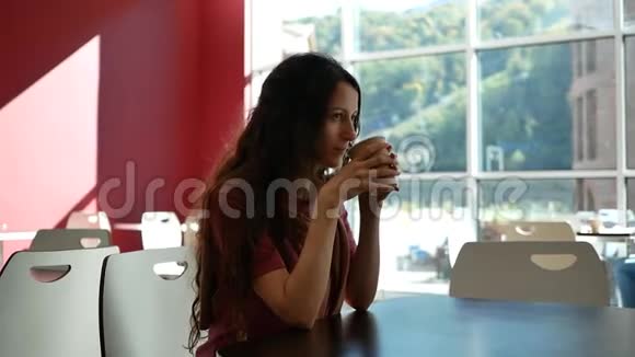 咖啡馆里美丽的年轻女子用纸杯喝咖啡视频的预览图