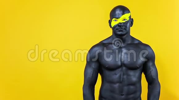 人有个好主意健美运动员有黄色的面部艺术和黑色的身体油漆他的彩色肖像和视频的预览图