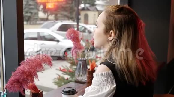 咖啡馆的年轻女子望着窗外等着某人喝咖啡视频的预览图