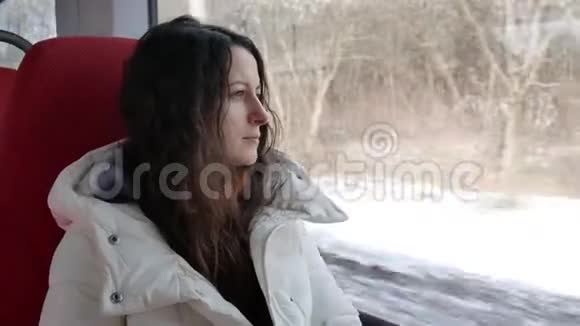 年轻女子坐在火车上沉思地望着窗外视频的预览图