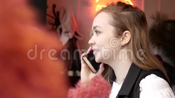 咖啡馆里的年轻女子在打电话视频的预览图