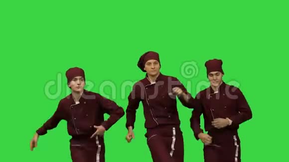 三个年轻的微笑厨师在绿色屏幕上跳舞Chroma键视频的预览图