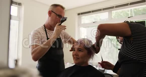 侧视妇女头发由两个理发师设计视频的预览图