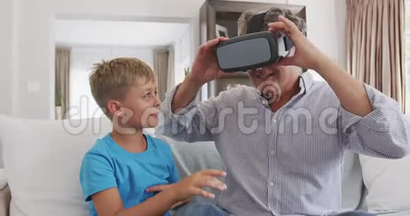 与孙子一起戴虚拟现实耳机的老人视频的预览图