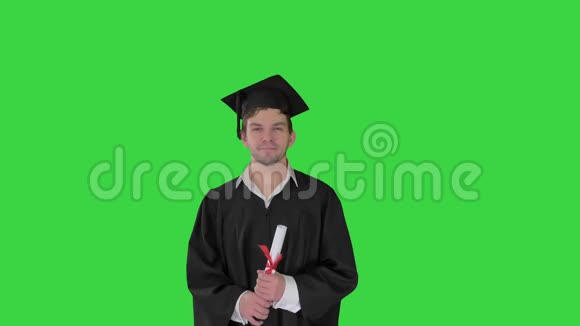 男毕业学生微笑着把帽子扔到绿色屏幕上Chroma键视频的预览图