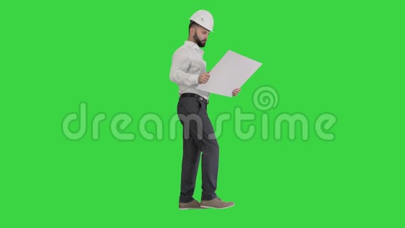 年轻的建筑建筑师走着看绿色屏幕上的蓝图Chroma键视频的预览图