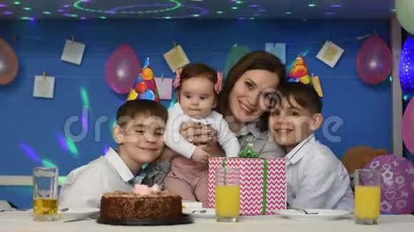 欢乐的家庭妈妈女儿和两个男孩在一个家庭生日聚会上看框架视频的预览图