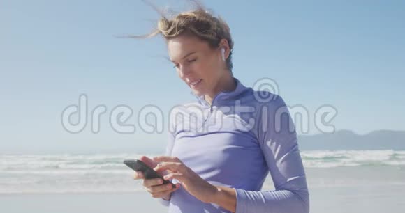 运动女性在海滩上听音乐视频的预览图