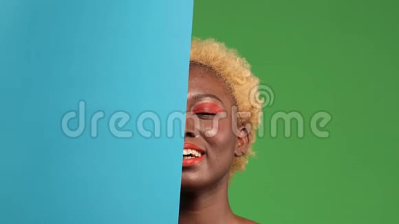 一个皮肤黝黑的年轻女子脸上挂着一个蓝色的背景脸上挂着一个与世隔绝的绿色视频的预览图