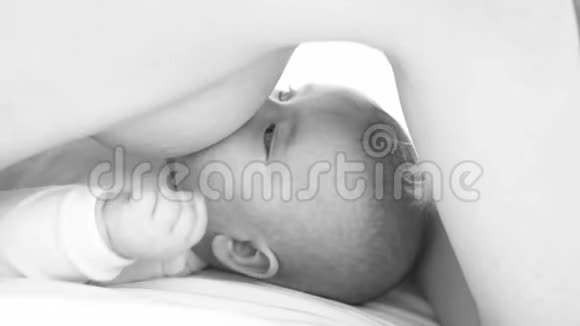 婴儿被母乳喂养吃谎言黑白的视频的预览图