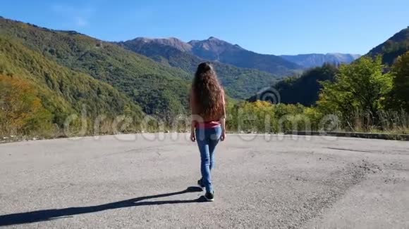美丽的年轻女子在日落时接近山崖自由概念视频的预览图
