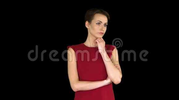 迷人的年轻女子穿着红色的裙子站着听别人说话阿尔法频道视频的预览图