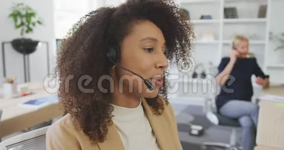女人用耳机对着顾客说话视频的预览图