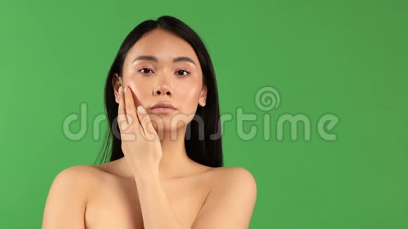 一个亚洲貌美的女孩光着肩膀银白色的面部表情看着摄像机视频的预览图