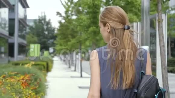 背着背包走过商业区的年轻女子视频的预览图