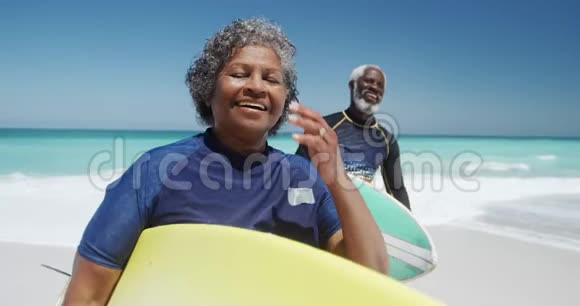 前景老夫妇在海滩上有冲浪板视频的预览图