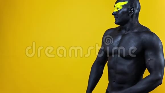 男人选择复制空间健美运动员有黄色的面部艺术和黑色的身体油漆他的彩色肖像和视频的预览图