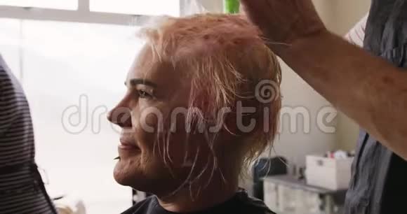 侧视妇女头发被理发师弄干视频的预览图