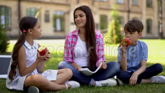 老师给孩子们吃苹果并在新鲜空气中继续上课视频的预览图