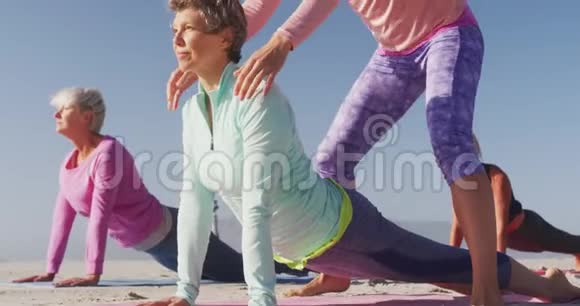 瑜伽老师在海滩上教老年妇女瑜伽视频的预览图