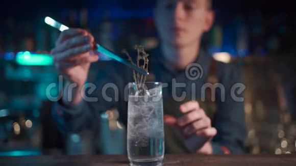 调酒师将现代杜松子酒鸡尾酒与冰块混合视频的预览图