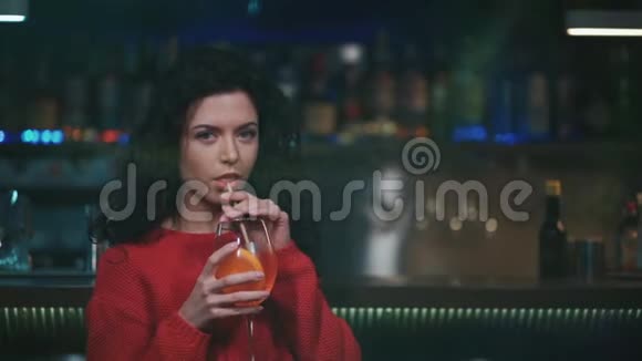 年轻卷曲的女性在夜总会喝美味的鸡尾酒视频的预览图