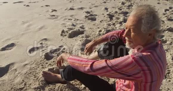 高视角老人坐在海滩上视频的预览图