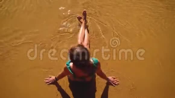 年轻的女孩在清澈的海水上用金色的沙子视频的预览图