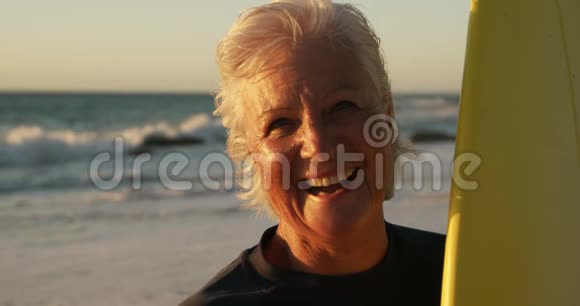 前景老人带着冲浪板微笑视频的预览图