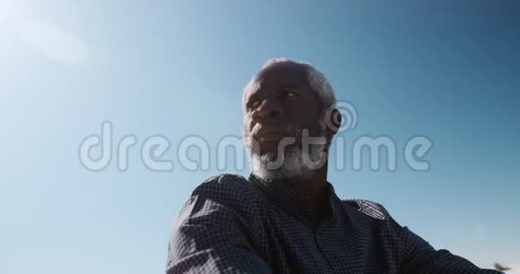 低角度视角老人坐在沙滩上视频的预览图