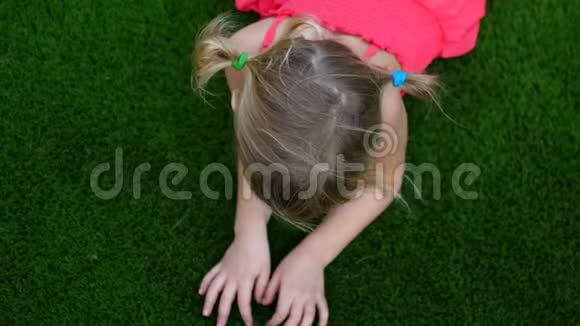 小女孩在草地上手在草地上视频的预览图
