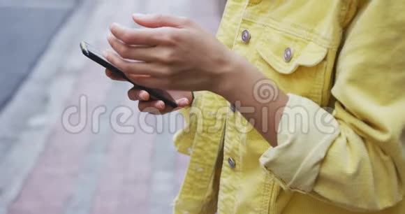 街头使用智能手机的混血女人视频的预览图