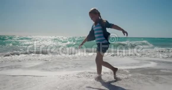在海边的水中散步的侧景女孩视频的预览图