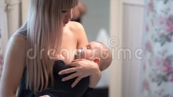 妈妈穿着黑色摇篮宝宝嘴里放着奶嘴视频的预览图