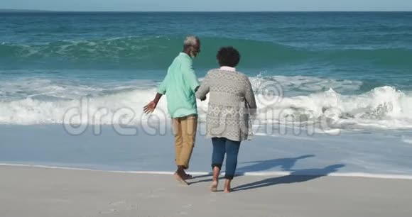 后景老夫妇穿过海滩视频的预览图