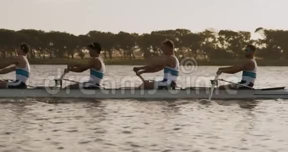男子划艇队在湖边划艇的侧景视频的预览图