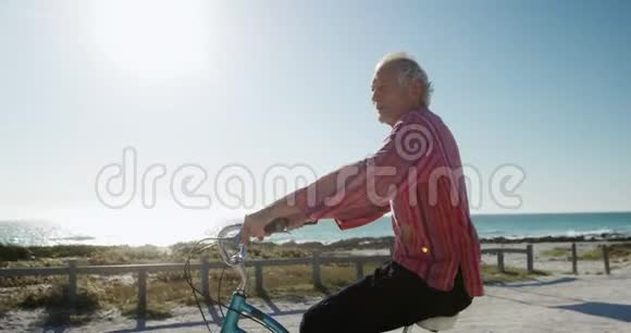 侧景老人在海滩骑自行车视频的预览图