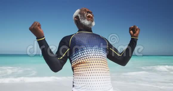 前景老人在海滩上举起双臂视频的预览图