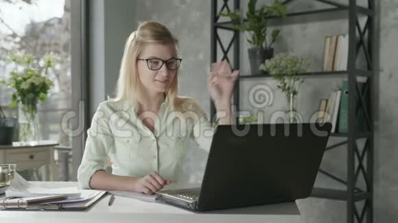 女企业家讨论视频电话与商业伙伴坐在桌子旁笔记本电脑旁边视频的预览图