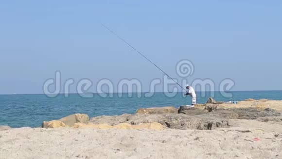 孤独的渔夫在岩石上视频的预览图