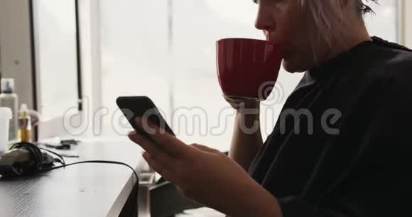侧视女士用手机喝咖啡视频的预览图