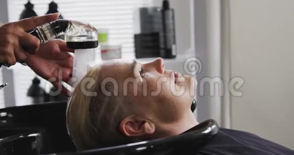 侧视妇女头发被理发师洗过视频的预览图