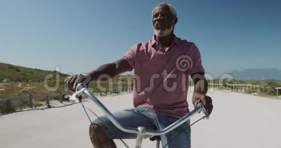 前景老人骑自行车靠近海滩视频的预览图