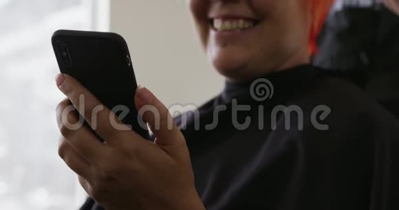 前景幸福的女人看着她的手机视频的预览图