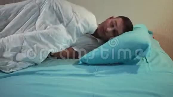 年轻人在一张舒适的床上开着灯上床睡觉安息吧视频的预览图