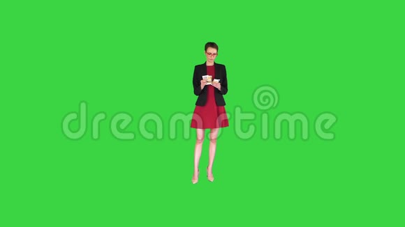 商务女性穿着红色连衣裙在绿色屏幕上扔钱Chroma键视频的预览图