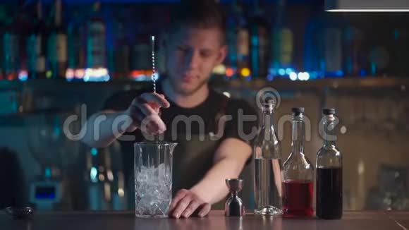 调酒师将经典的negroni鸡尾酒与朗姆酒和冰块混合视频的预览图